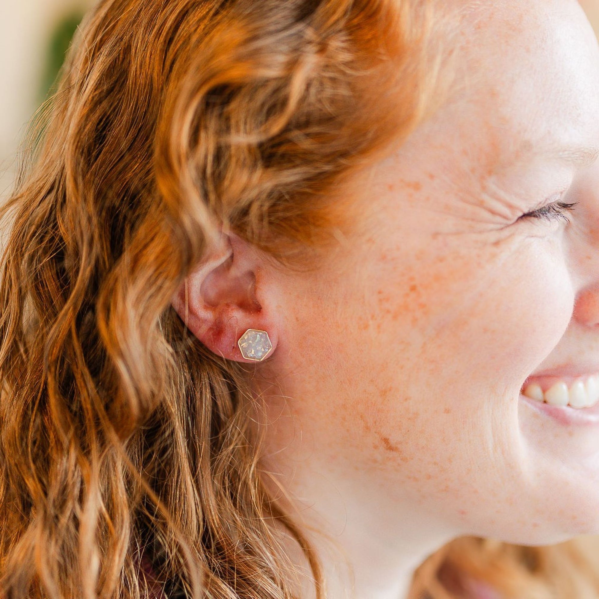 opal clay hexagon studs on smiling model