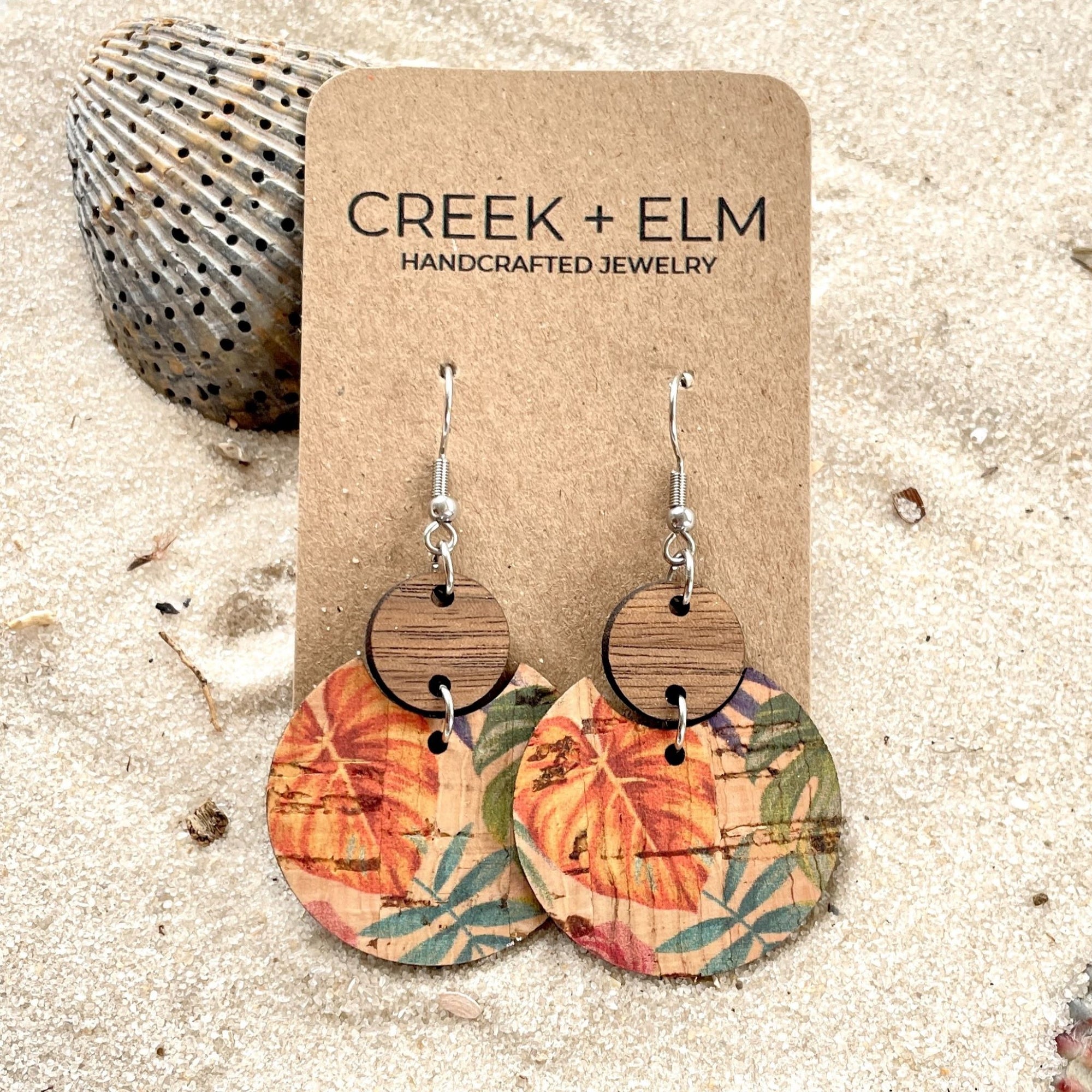 cora cork and wood earrings in painted canopy pattern on sand background on earring card