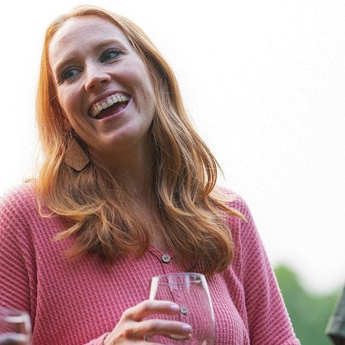 laughing mom drinking wine and wearring bold statement large dangly cork earrings