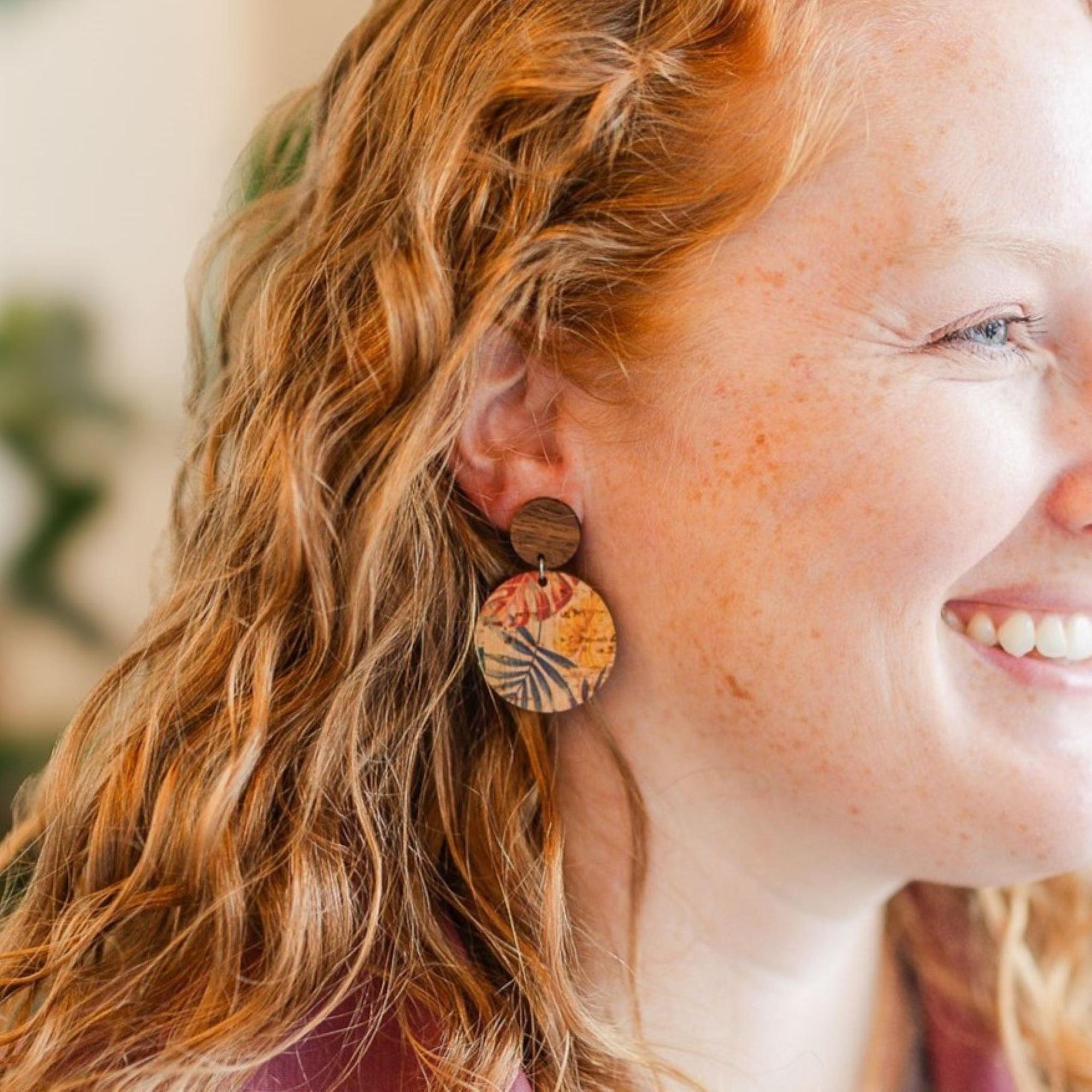 model wearing liyra painted canopy cork and wood earrings smiling