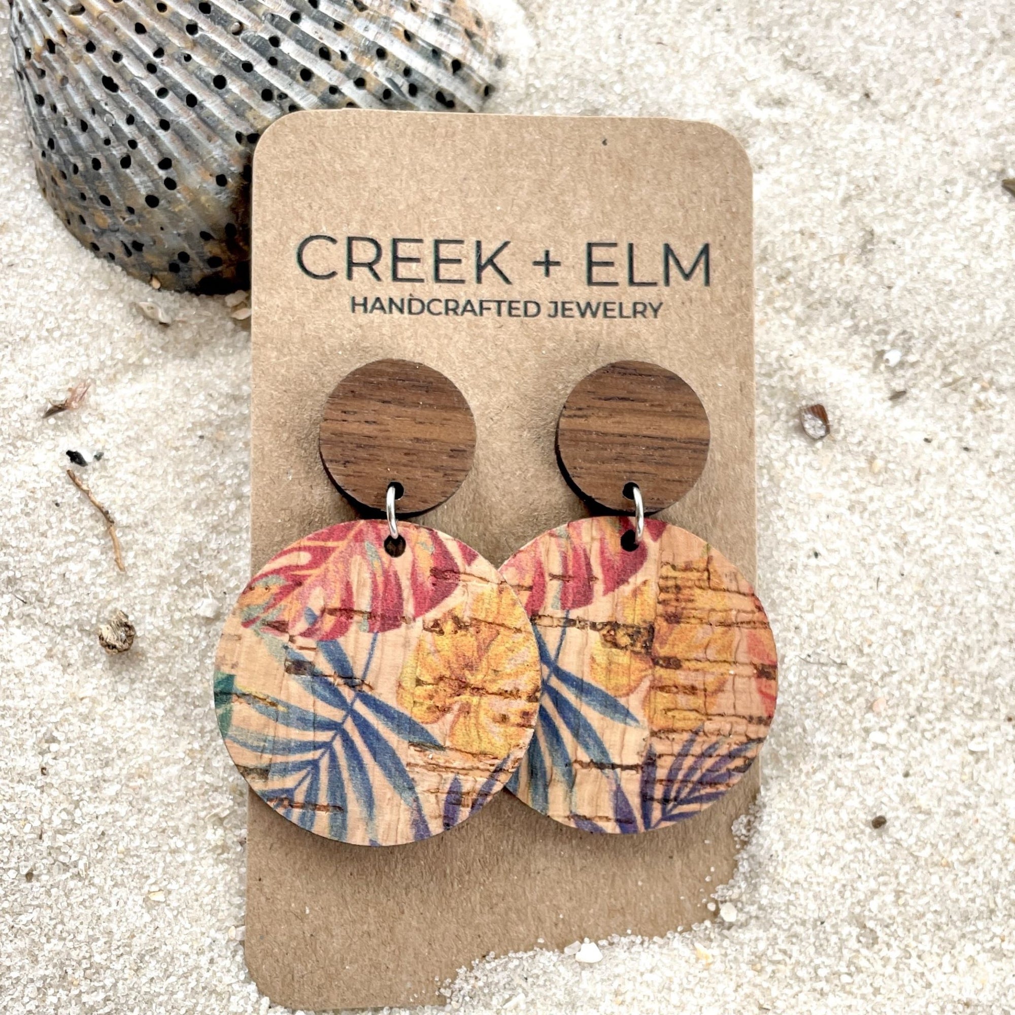 liyra painted canopy cork and wood earrings on sand background with seashells