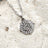 journey stainless steel silver necklace on sand background close up