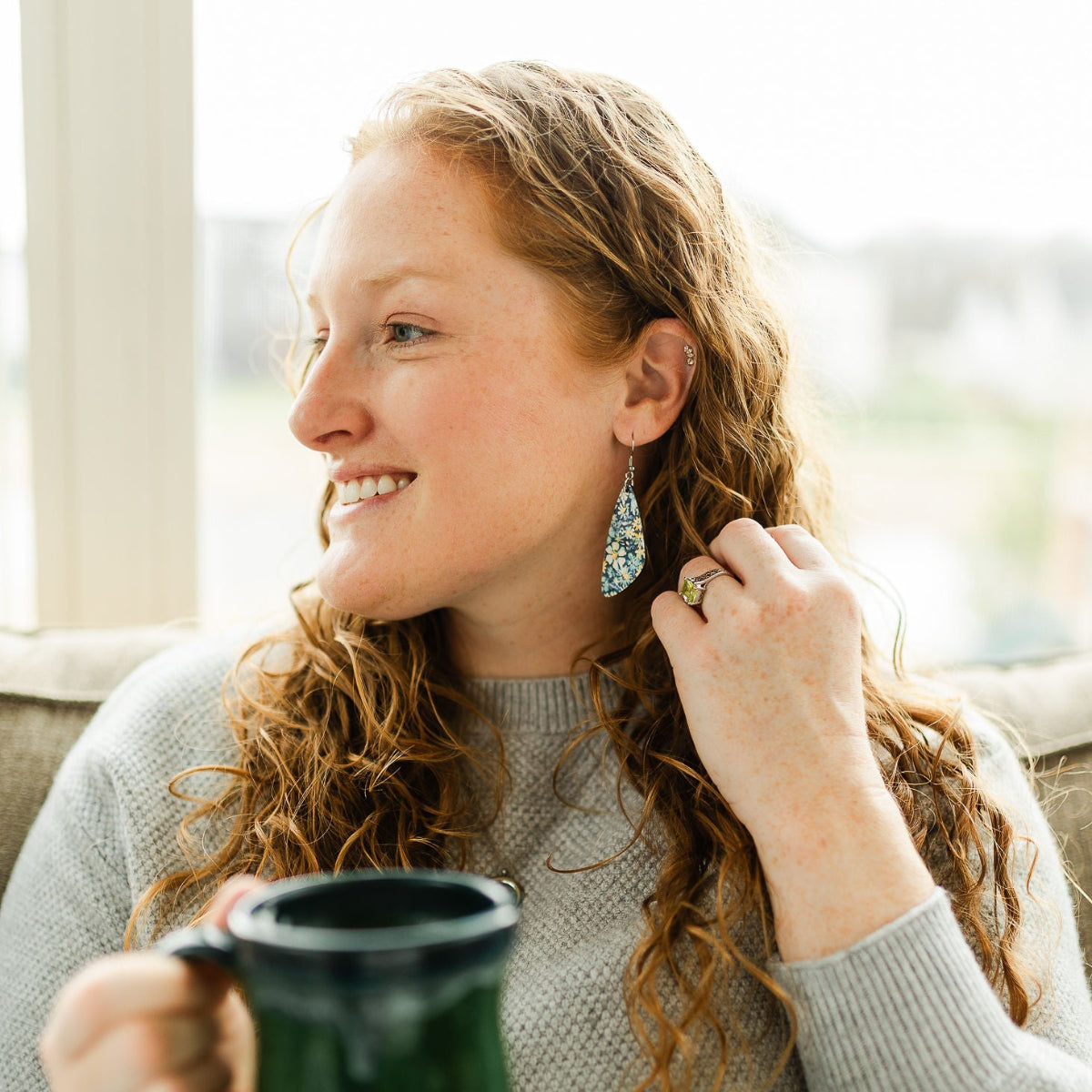 Woman wearing the Eliza blue floral cork teardrop earrings 