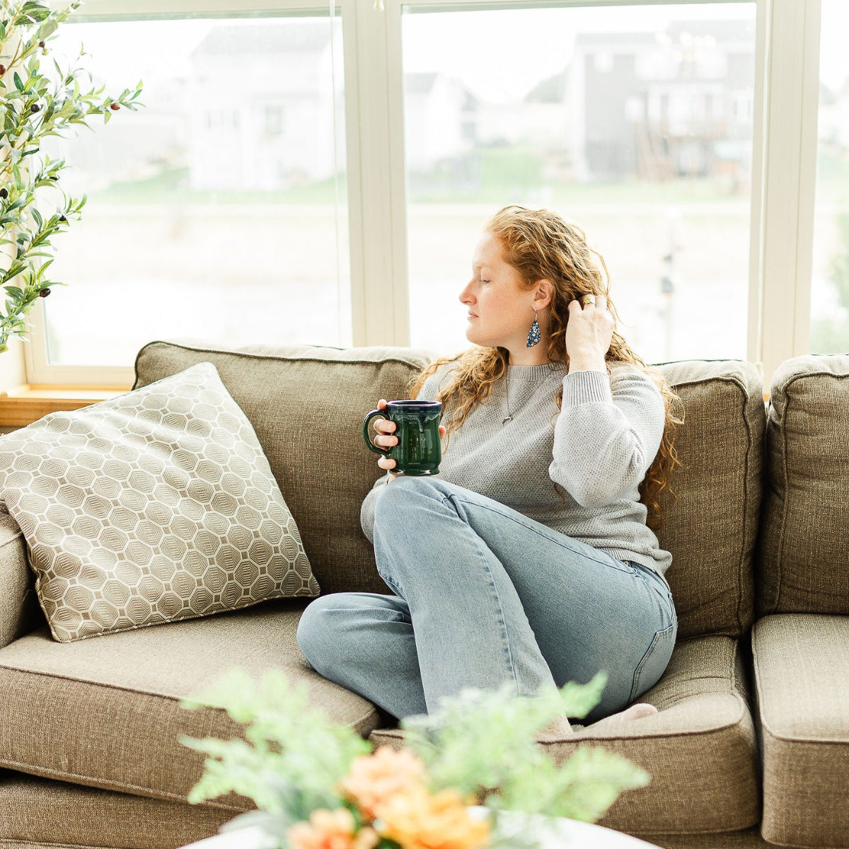 Woman on couch holding a cup 