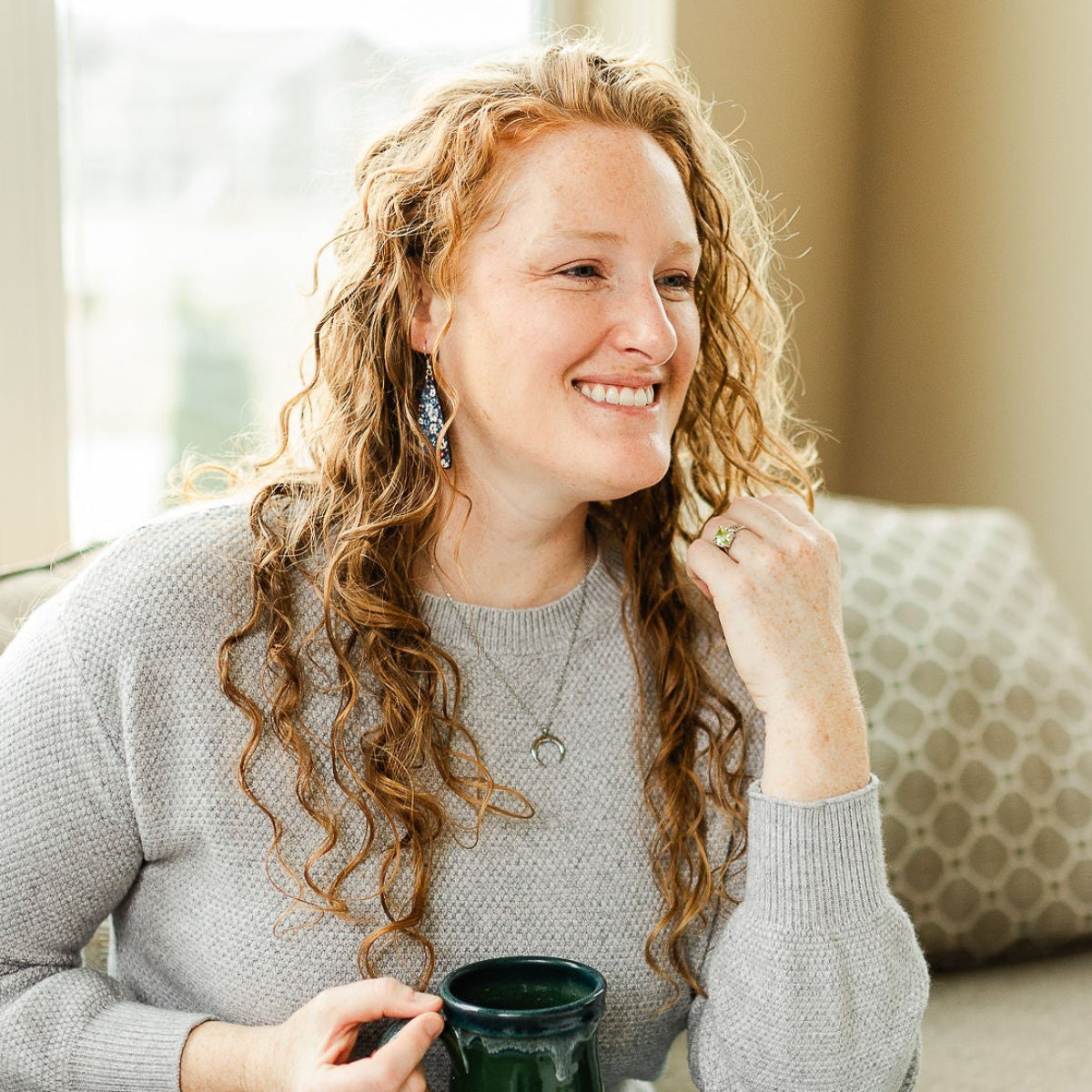 woman smiling holding coffee wearing eliza teardrop patriotic cork earrings