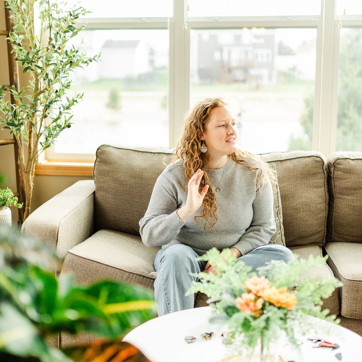 Woman chilling on a couch while combing her hair