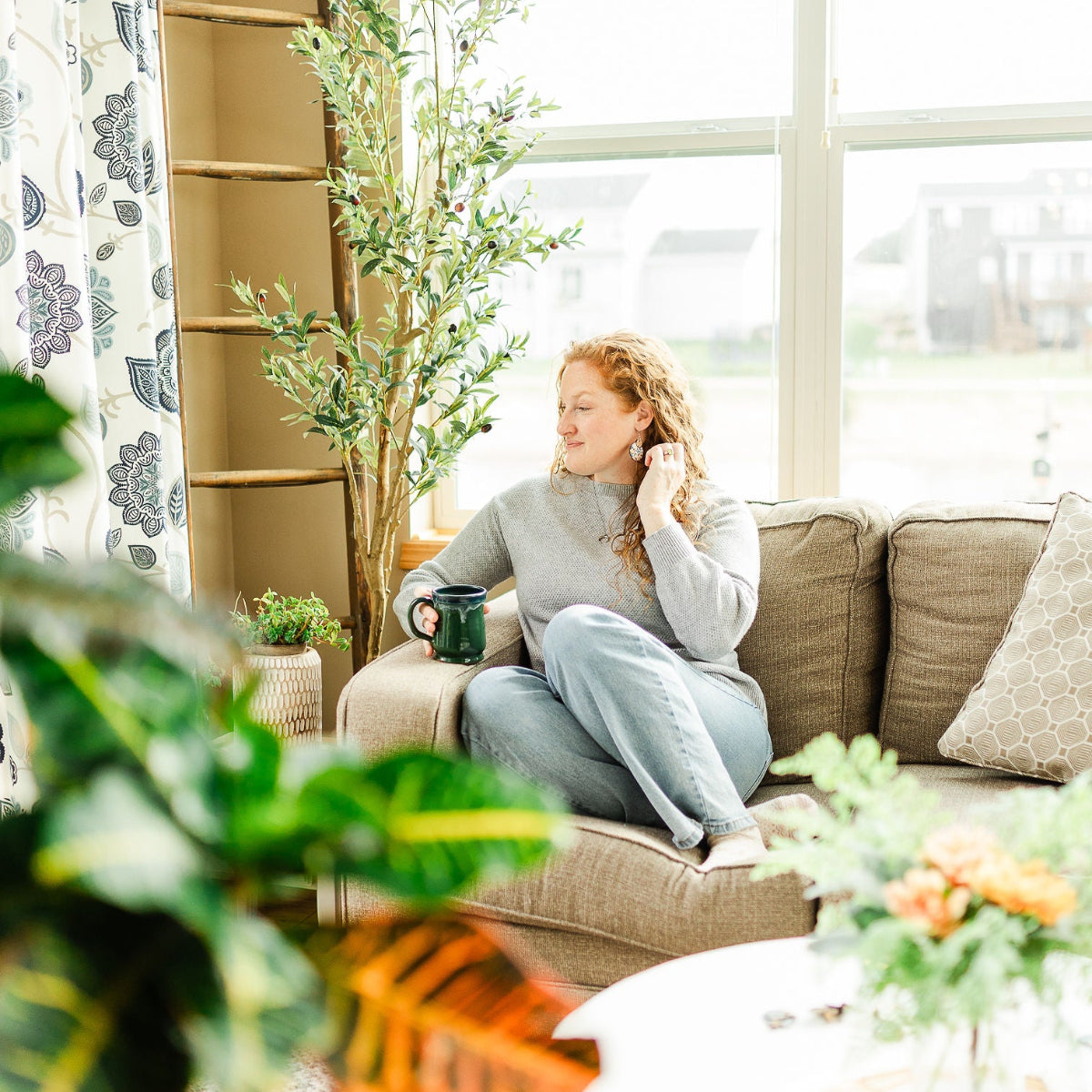 Woman holding a cup while chilling on the couch