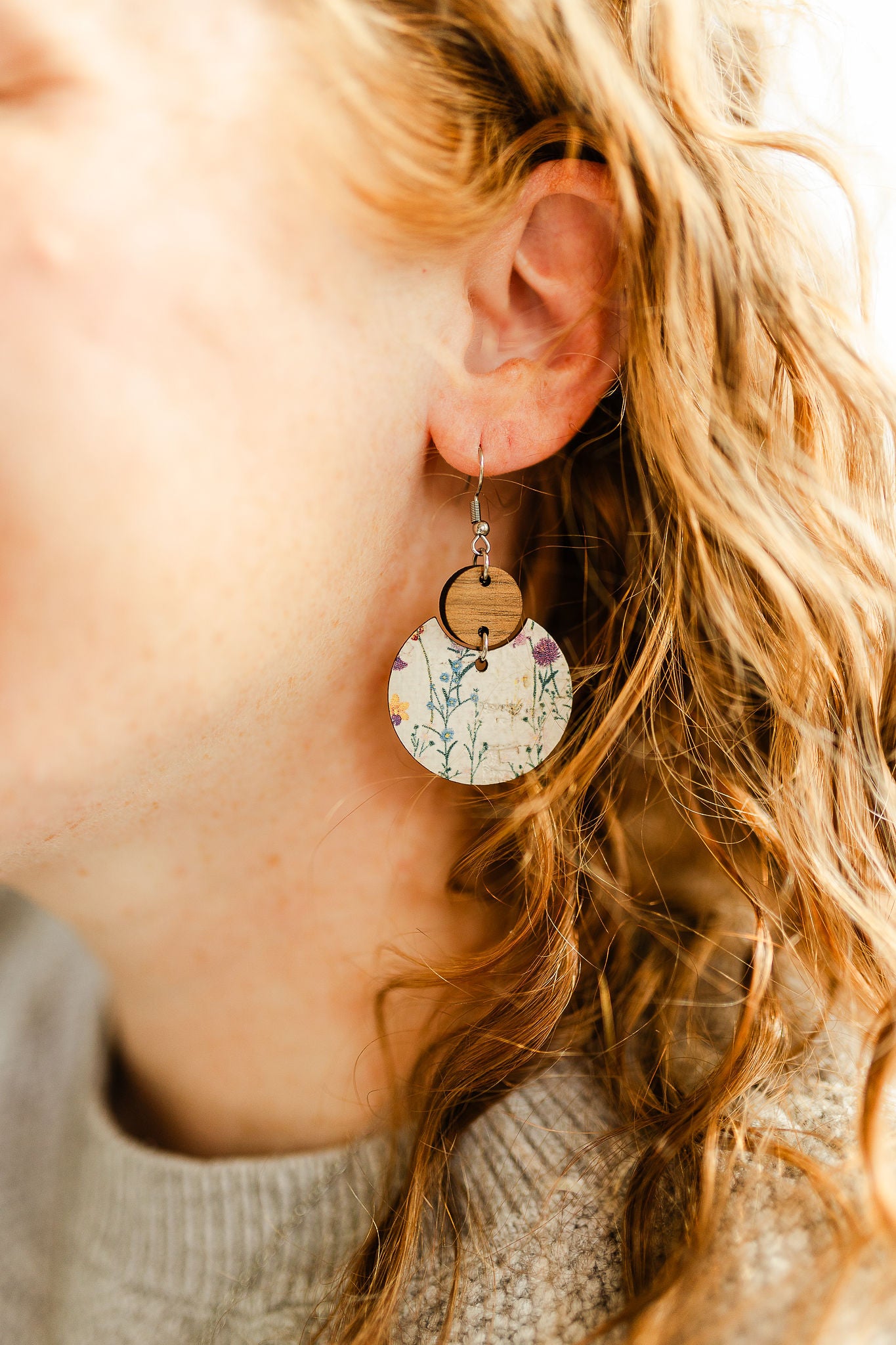 Close up of the Wildflower cork and walnut earrings worn on one ear