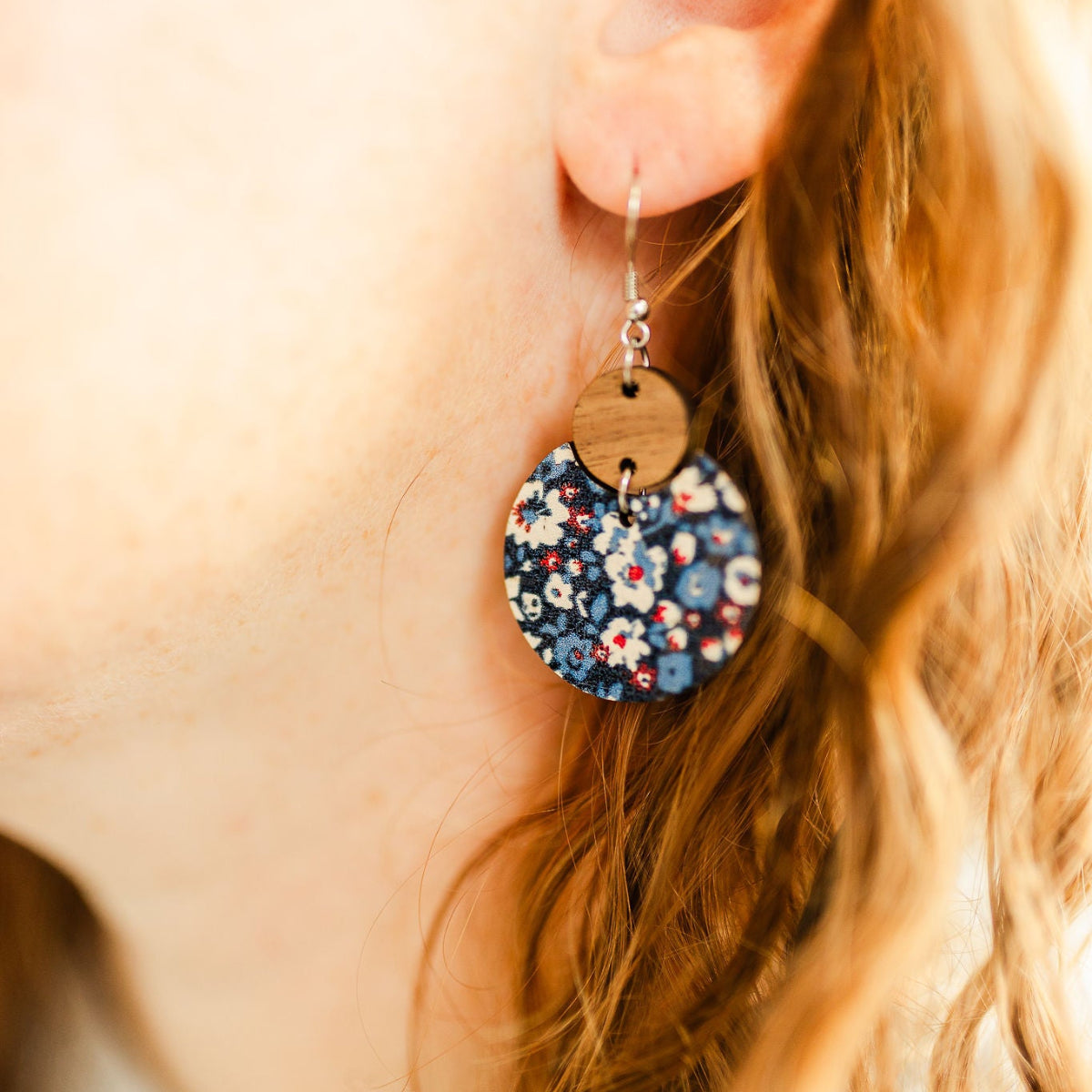 Close up look of the Cora Patriotic Poppies cork and walnut earrings worn on one ear