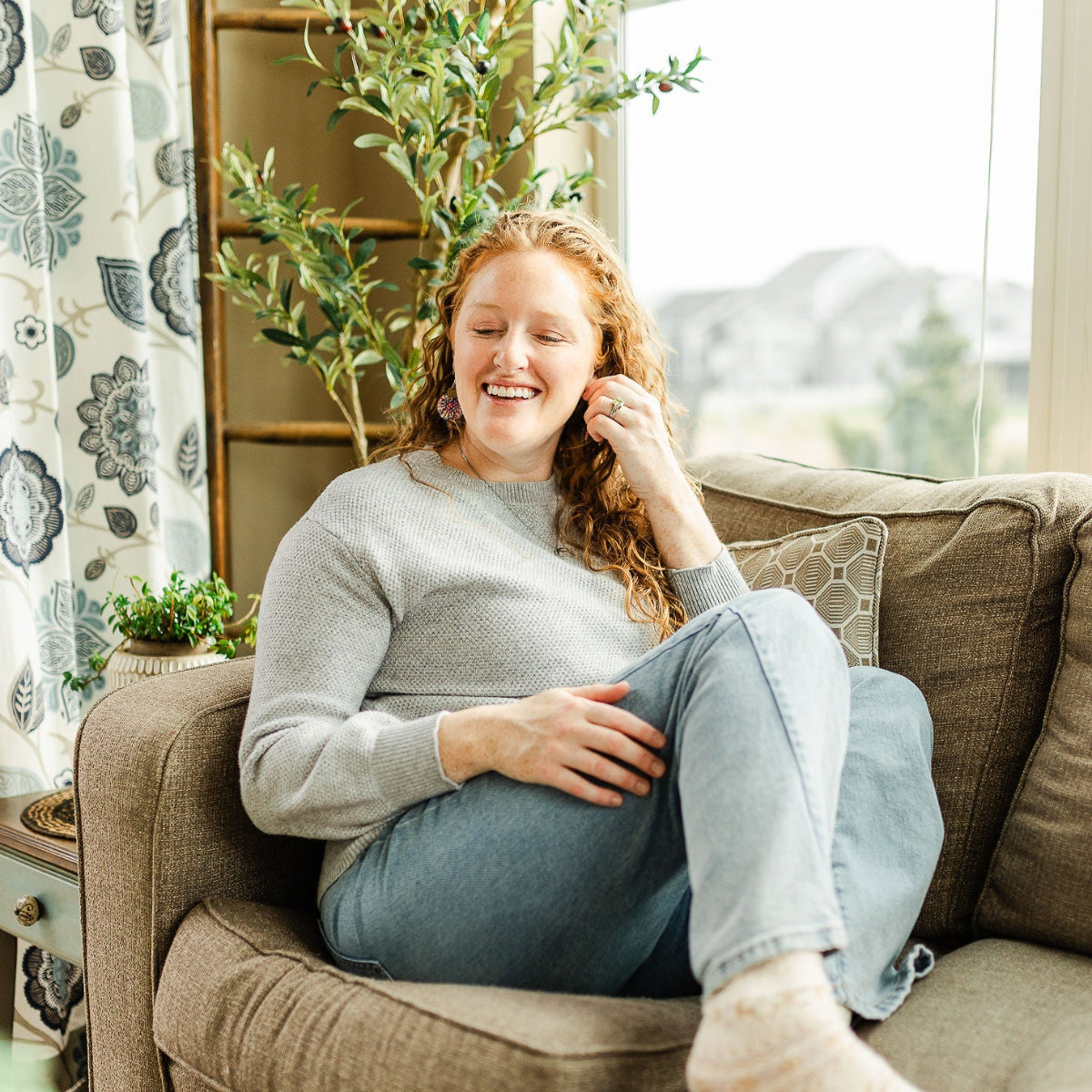 Woman sitting on chair while enjoying the Cora Star Spangled cork and walnut earrings
