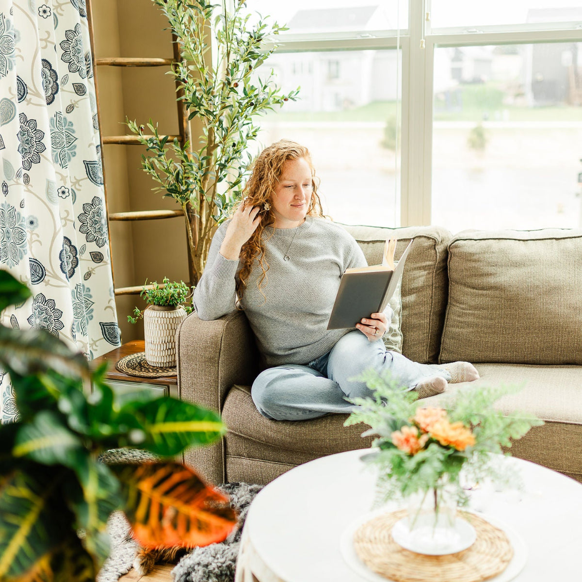 woman reading a book on a couch