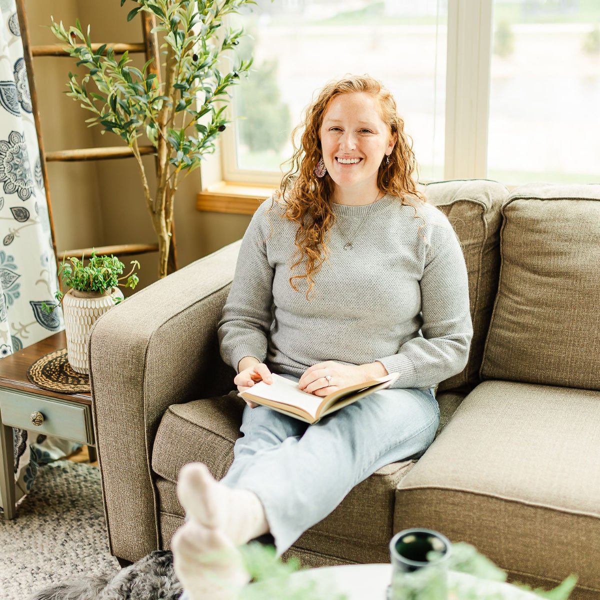Woman holding a book while sitting on the couch