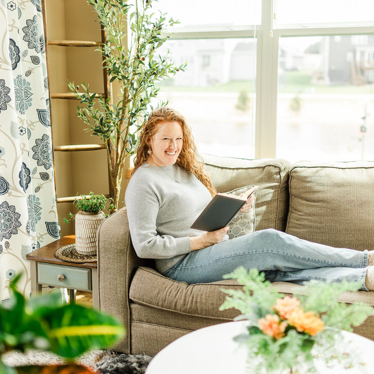 Woman on a sofa holding a book