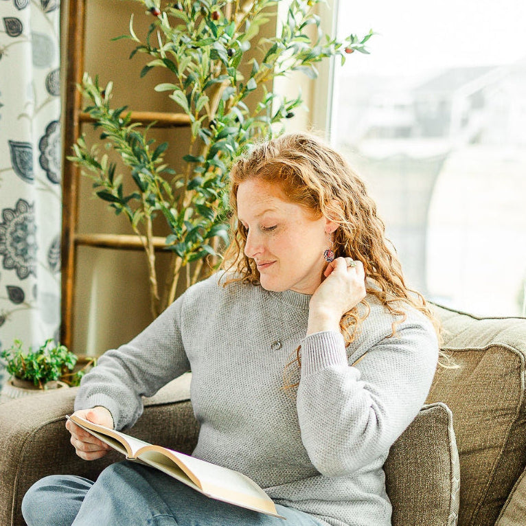Woman reading a book while sitting on a sofa