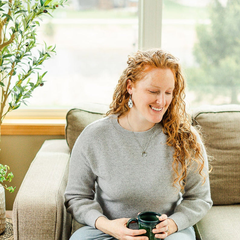 Woman enjoying her cup of coffee on a couch