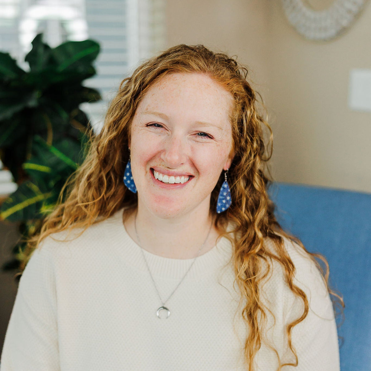 Woman smiling on camera while wearing a Creek+Elm earring