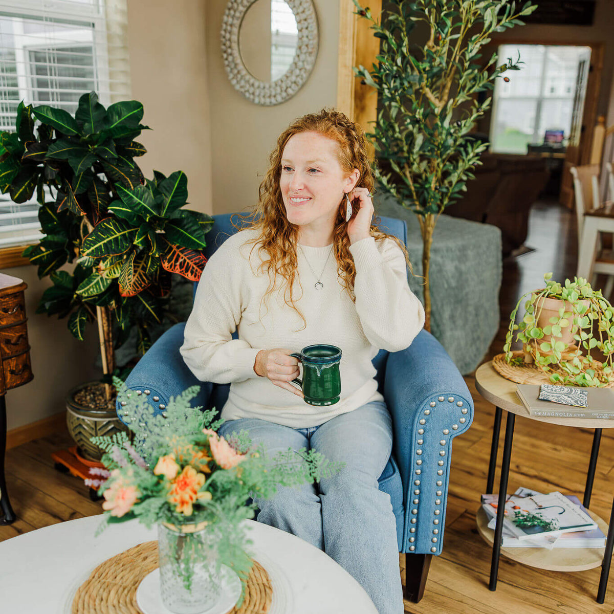 Woman on couch holding a green mug 