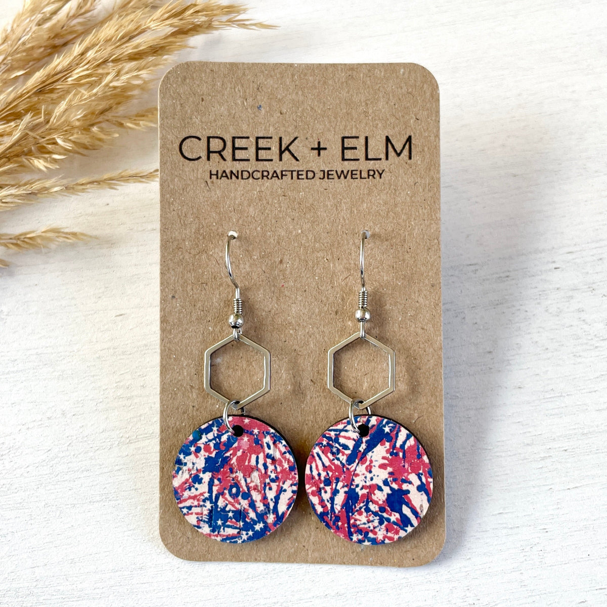 Silver Elizabeth star spangled cork and hexagon earrings on packaging