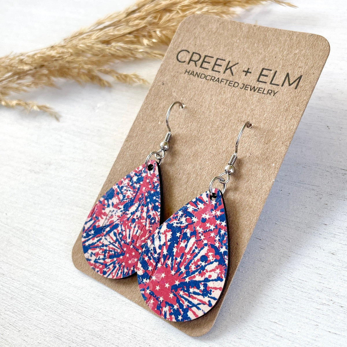 Mini Silver Kendra star spangled cork teardrop earrings on packaging