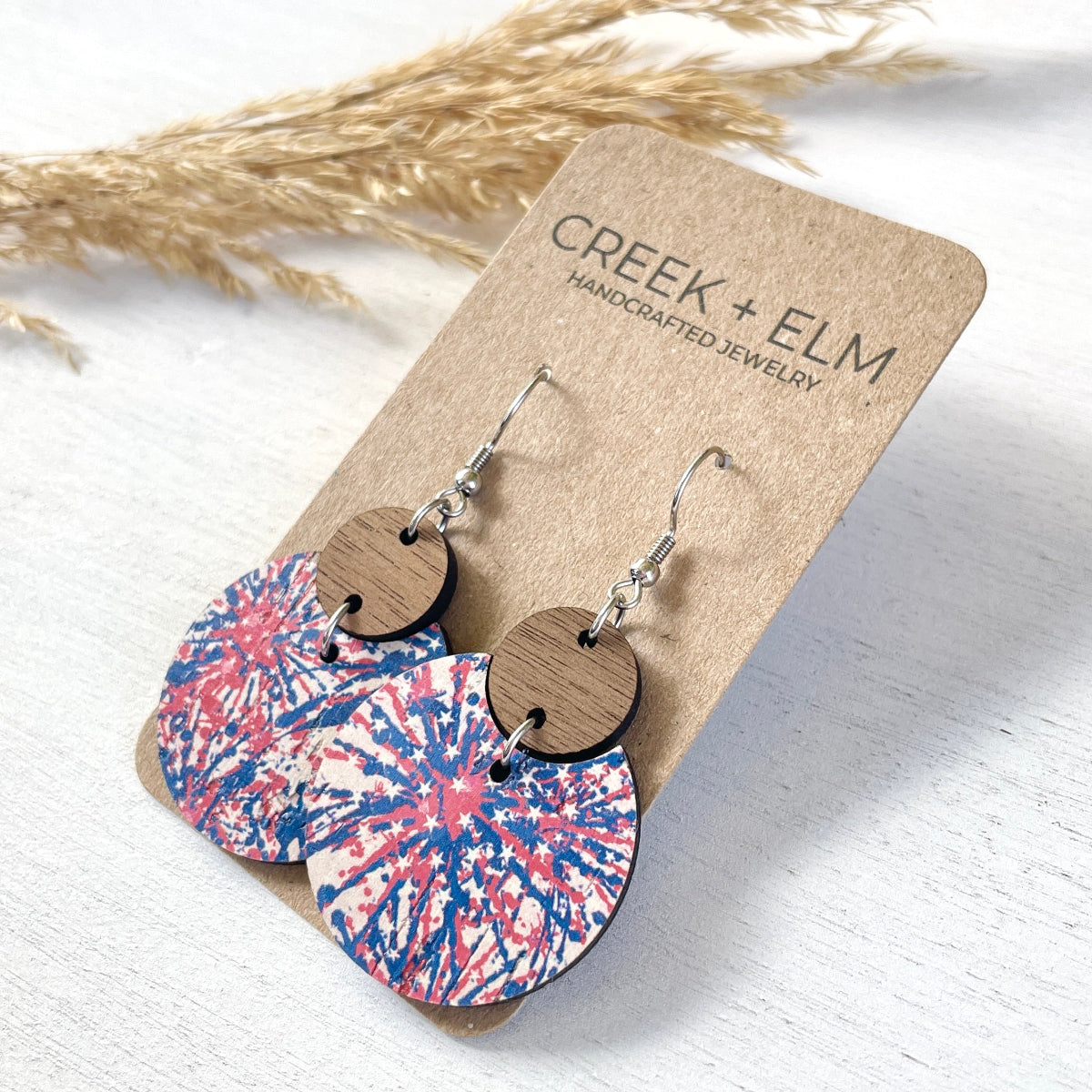 Side view of the Cora Star Spangled cork and walnut earrings on packaging