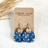 Close up of the Cora Denim Stars cork and walnut earrings on Creek+Elm Packaging