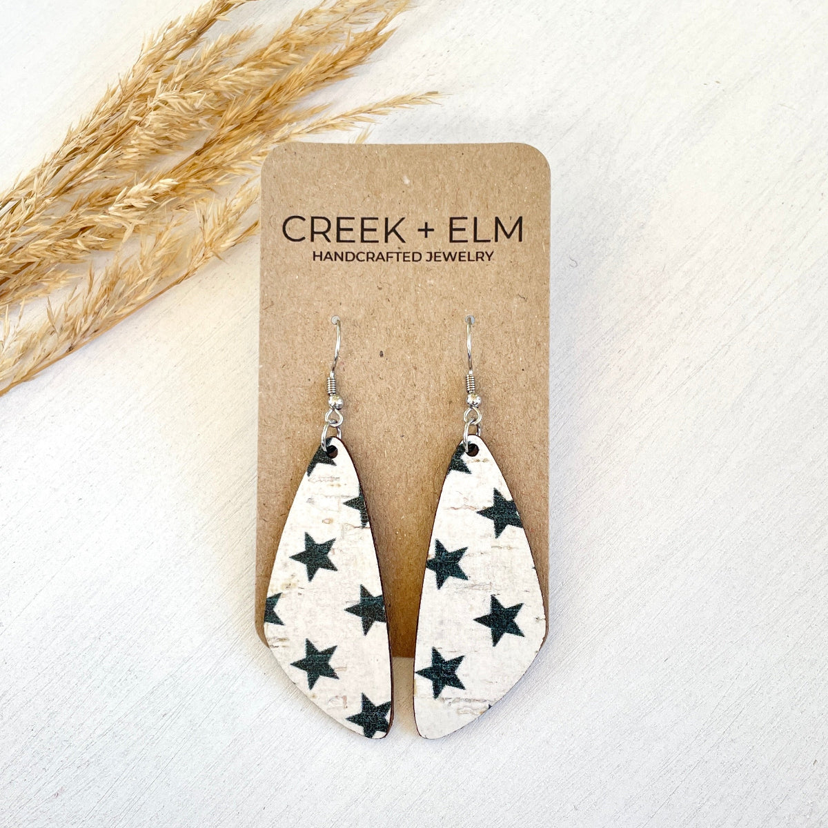 Flat lay photo of earrings displayed on a Creek & Elm packaging