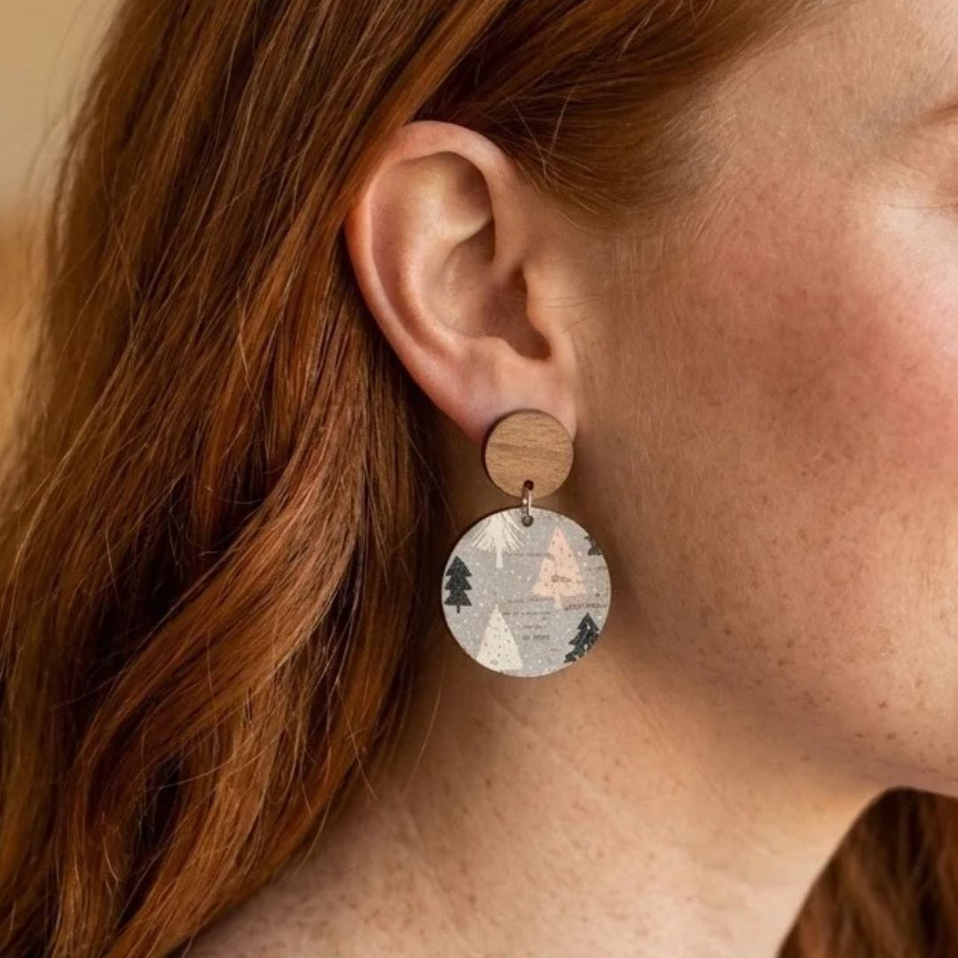 woman wearing cork and walnut circle earrings in a fun woodsy pattern