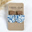 Blue dotted cork earrings with walnut trapezoid post and curved drop on packaging