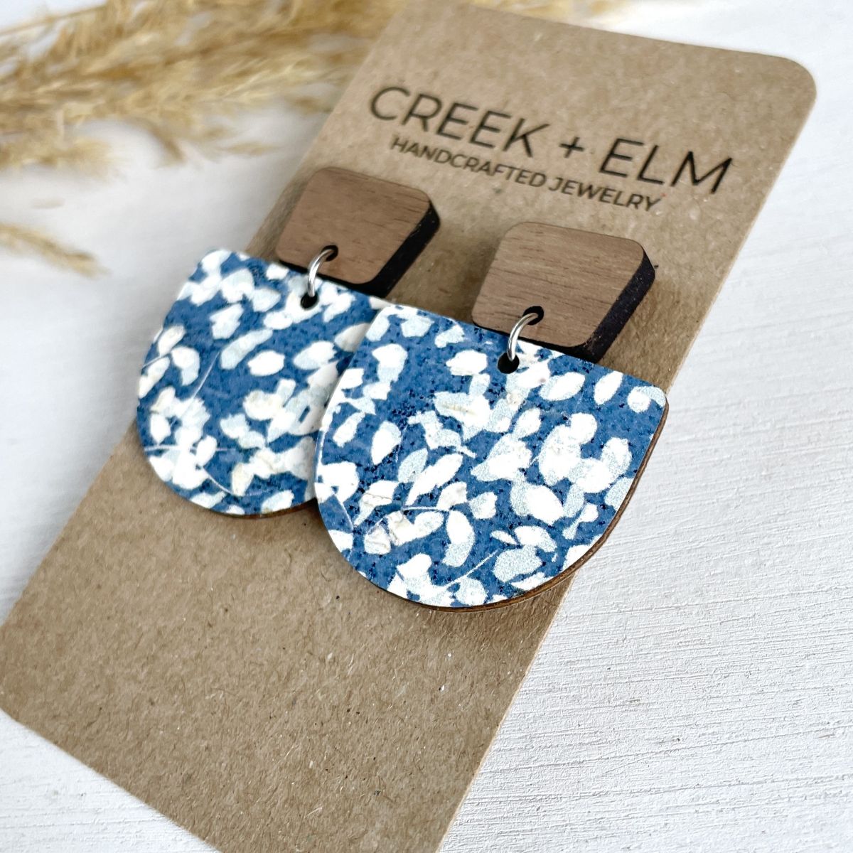 Side view of the Blue dotted cork earrings on a packaging