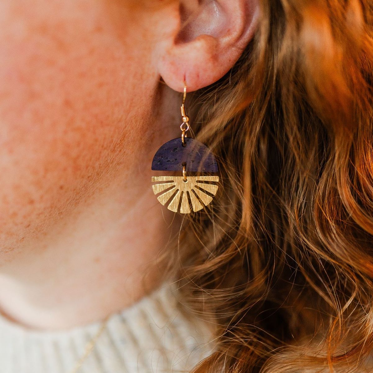 Eggplant earrings with gold starburst detail and deep tone on packaging