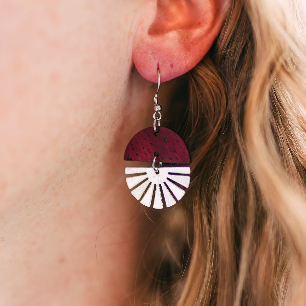Deep red wine earrings with silver starburst detail and rich tone on packaging