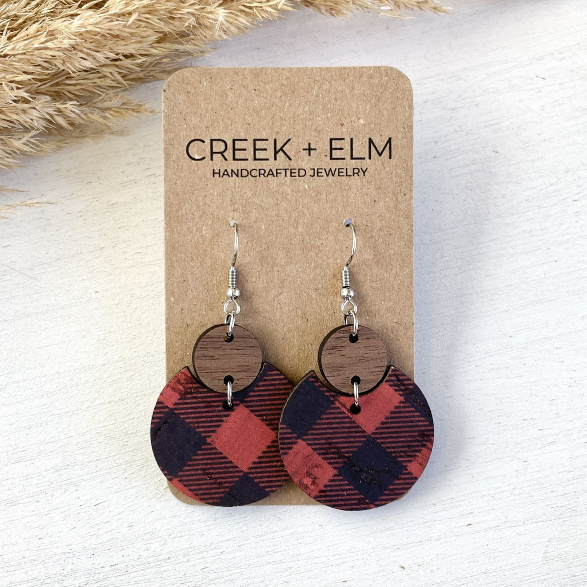 red buffalo plaid cork cutouts nested into a walnut circle on a fish hook