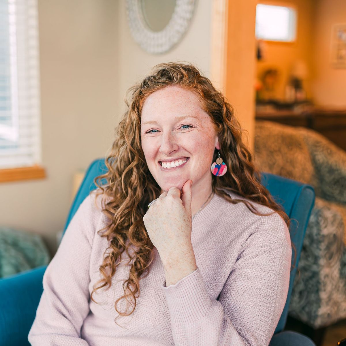 A woman smiling and showcasing the Summer sunset cork and walnut earrings