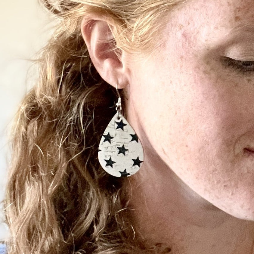 on ear close up of blue star cork teardrop earrings