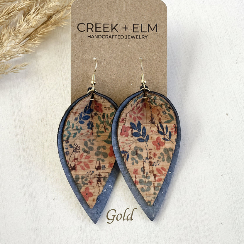 Teardrop-shaped earrings with floral pattern on a 'Creek + Elm' branded card.