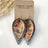 Teardrop-shaped earrings with floral pattern on a 'Creek + Elm' branded card.
