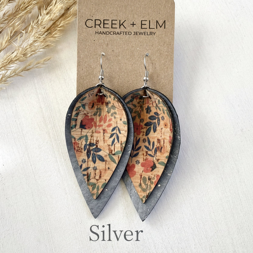 Teardrop-shaped earrings with floral pattern on cork material, displayed on a Creek + Elm branded card.