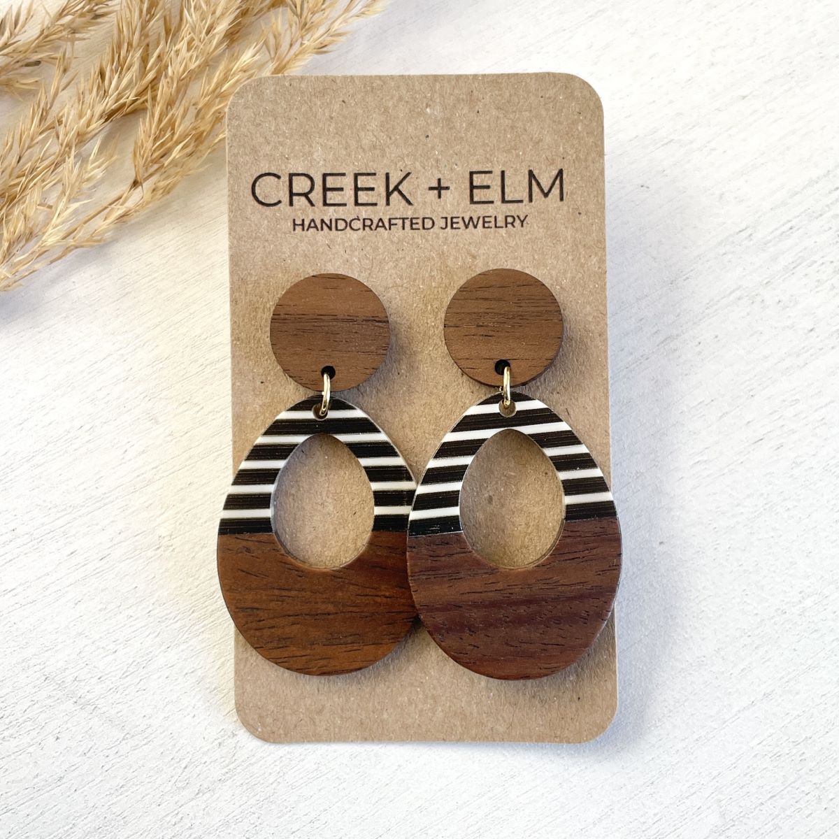 Luna black and white striped wood and resin open oval earrings on packaging