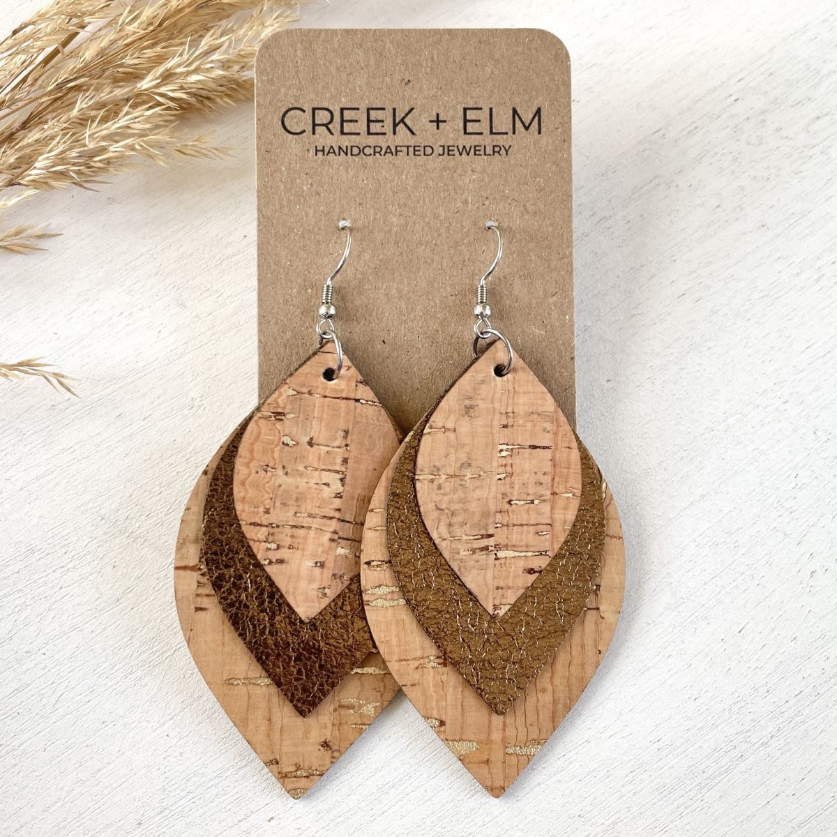 Macy natural cork leaf earrings with gold flecks and layered vegan leather design on a white background with a different pattern