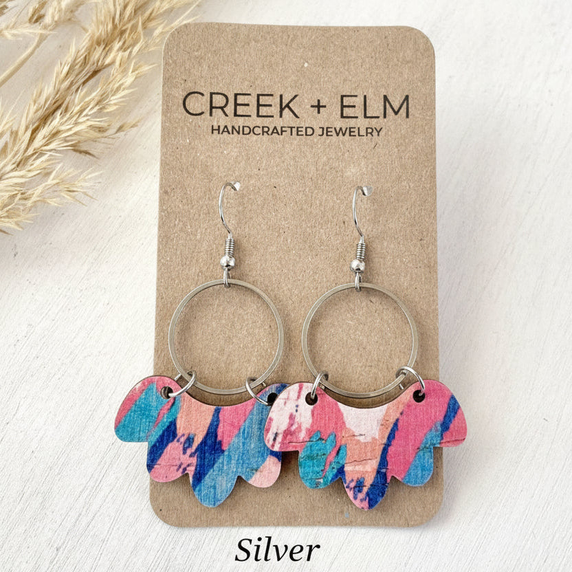 Colorful earrings on a Creek + Elm branded card with dried grasses on the side.