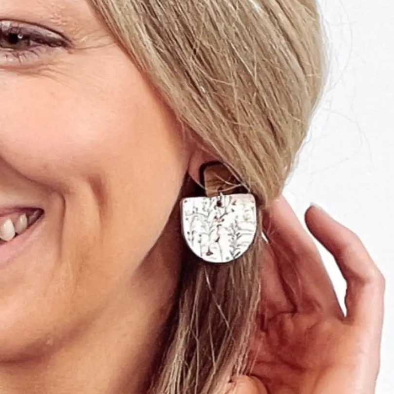 Close up of a woman wearing Wildflower cork earrings