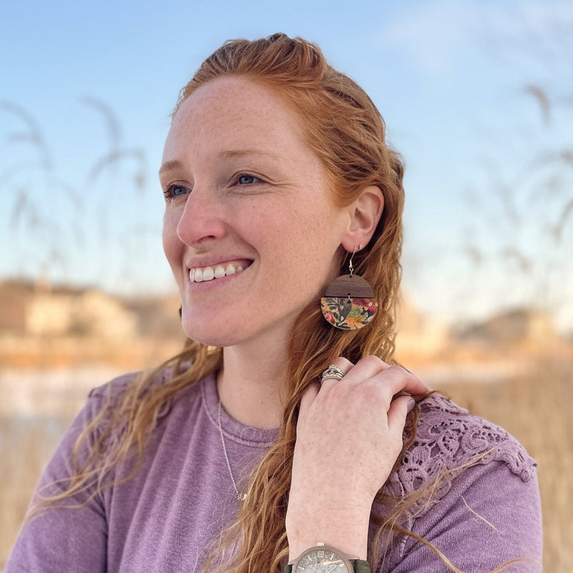 model smiling while wearing Everly Tropical Floral Cork &amp; Wood Earrings, with bold tropical print clearly visible.