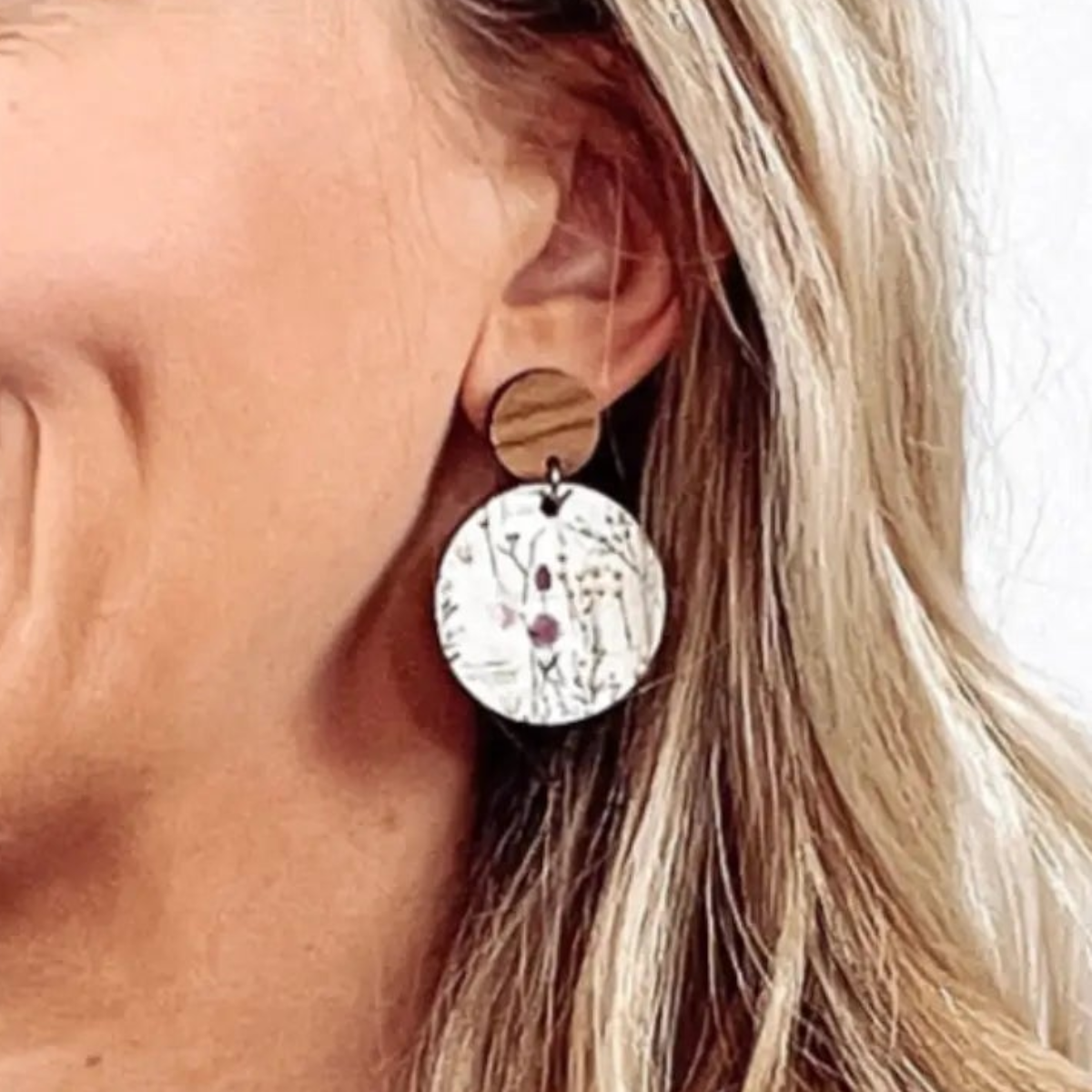 Smiling model wearing wildflower print cork circle earrings 